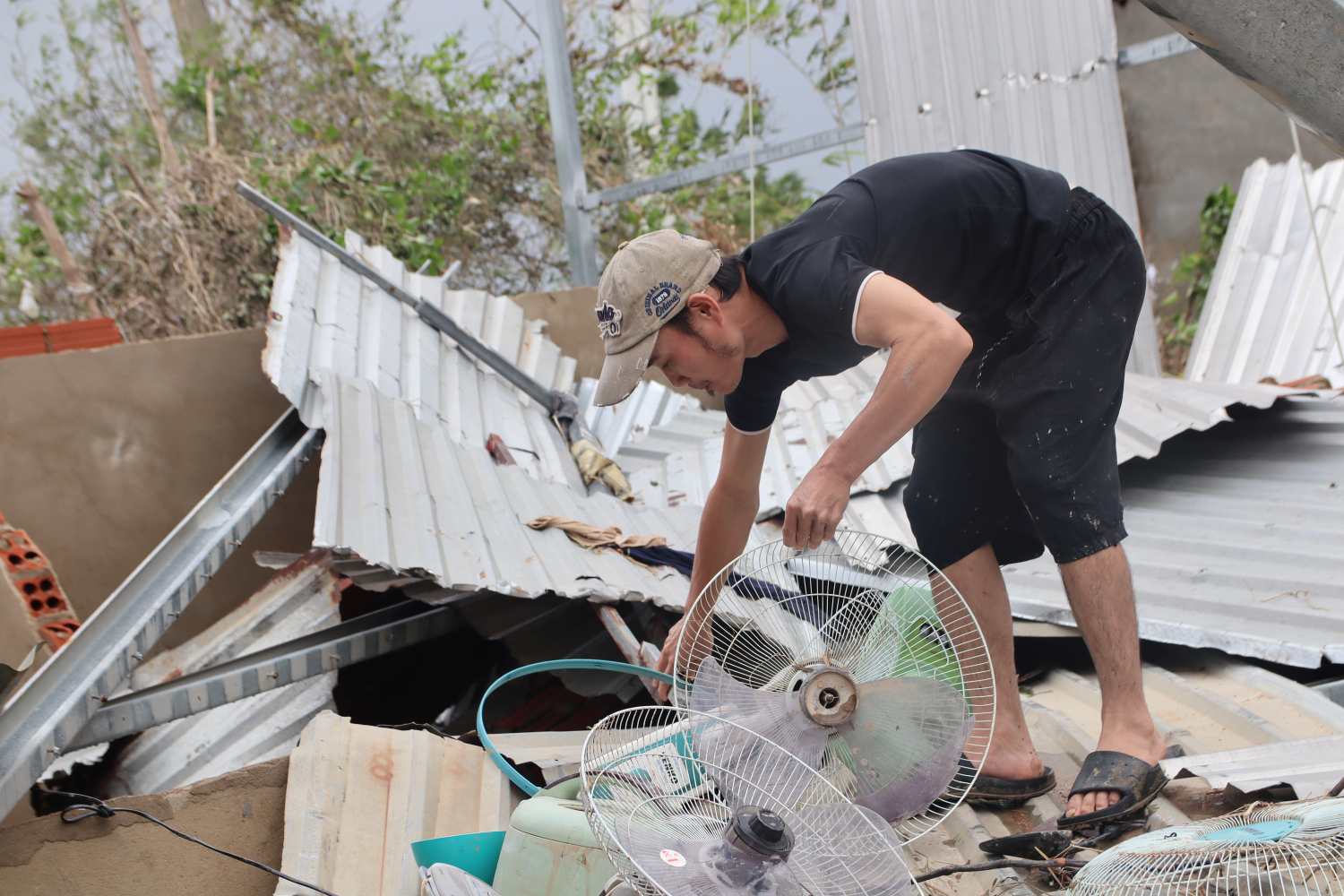 Anh Nguyen Quoc Toan nhat lai nhung chiec quat tren ngoi nha do nat. Anh: Phuong Linh