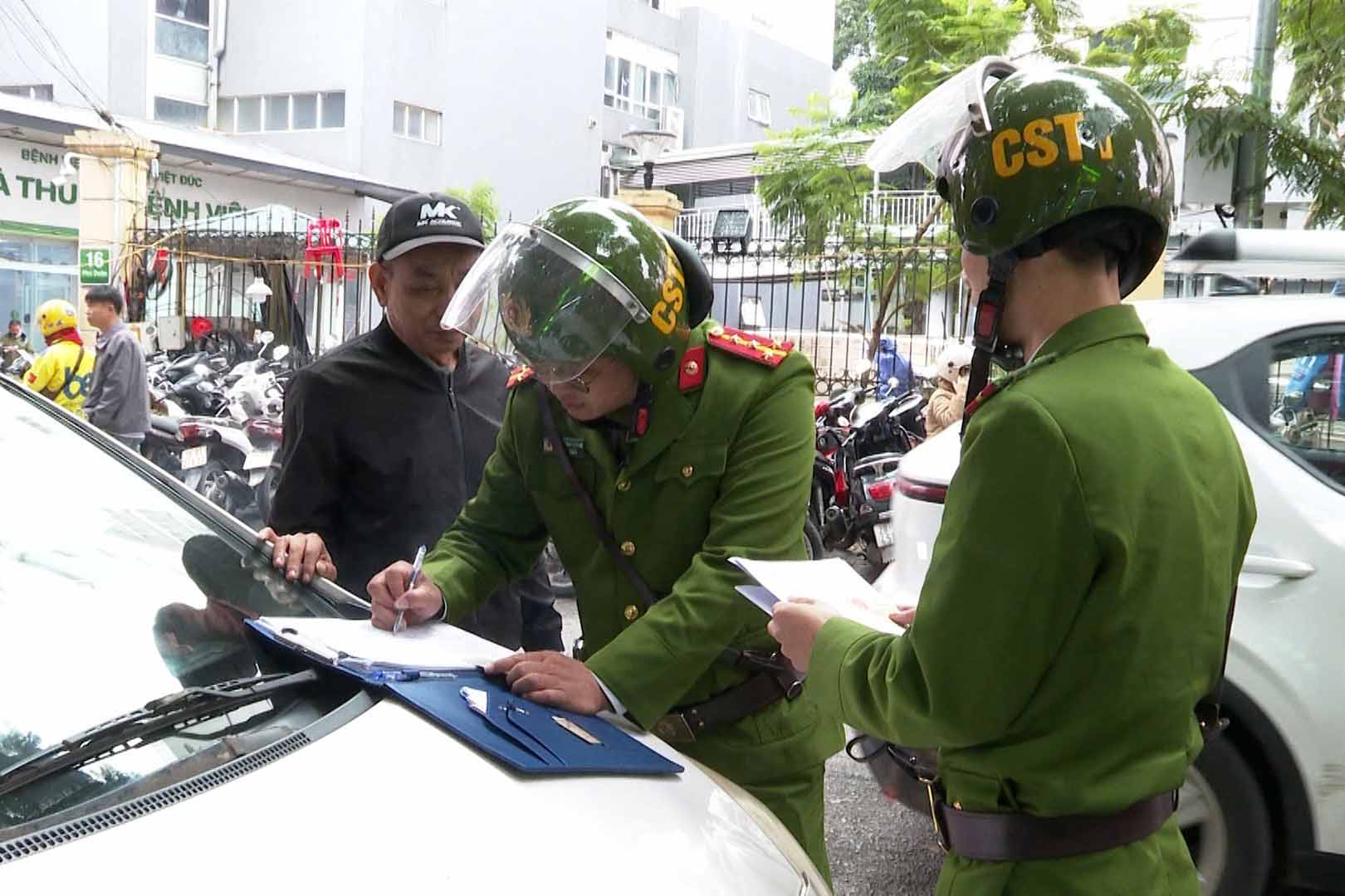 Lực lượng Công an phường Hoàn Kiếm (Hà Nội) lập biên bản xử lý vi phạm dừng, đỗ xe sai quy định. Ảnh: Ngọc Bích 