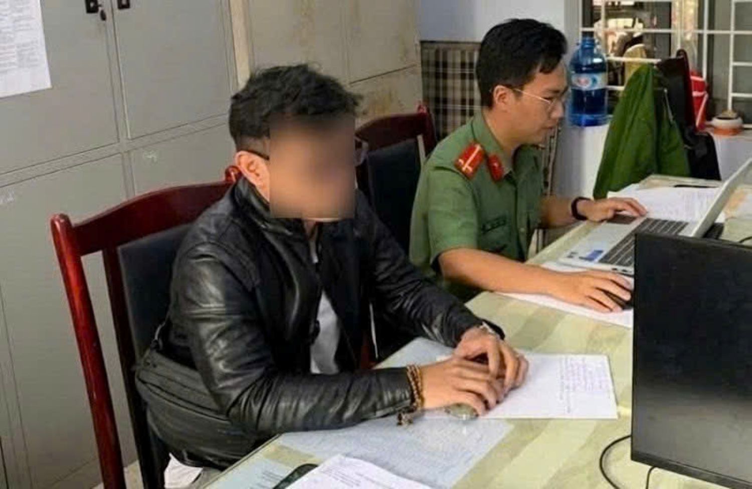 Anh N.Q.Đ làm việc với cơ quan chức năng liên quan đến việc đưa tin lũ lụt sai sự thật Ảnh: Công an