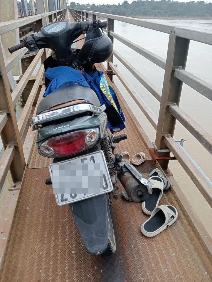 Nguoi dan ong bo lai xe may, om hai chau be nhay xuong song Tra Khuc tu tu. Anh: Linh Van