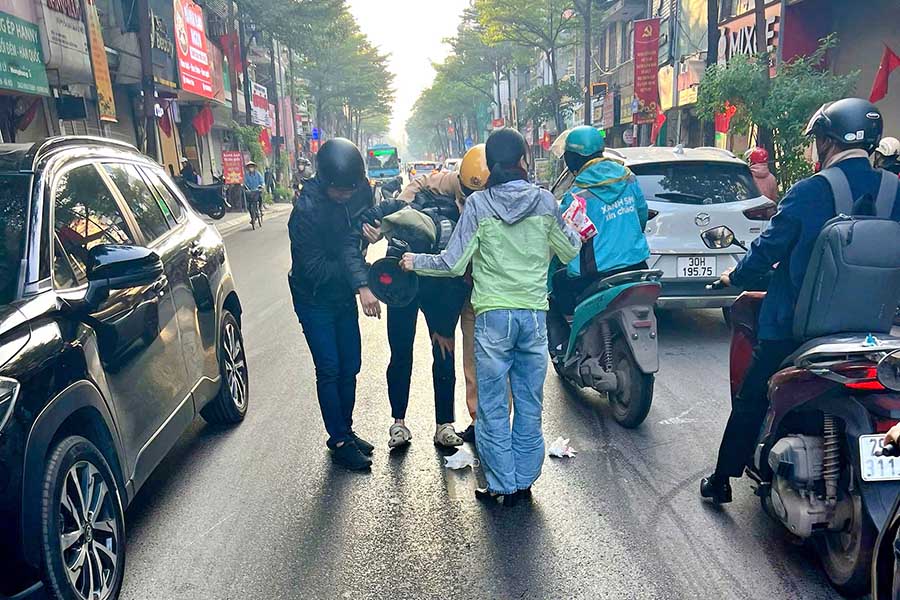 警察と住民が滑り込んだバイクに乗っている人を支援しています。写真:警察提供