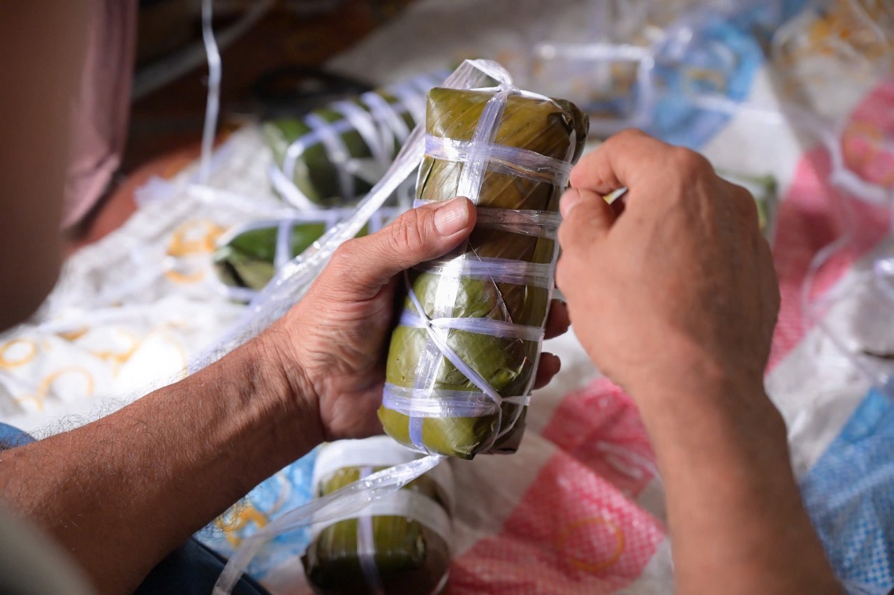 Mot khong khi tat bat nhung am ap dien ra suot buoi, nguoi vo gao, rua la chuoi, nguoi quat lua, nhom bep, nguoi goi banh roi xep tung banh vao noi.