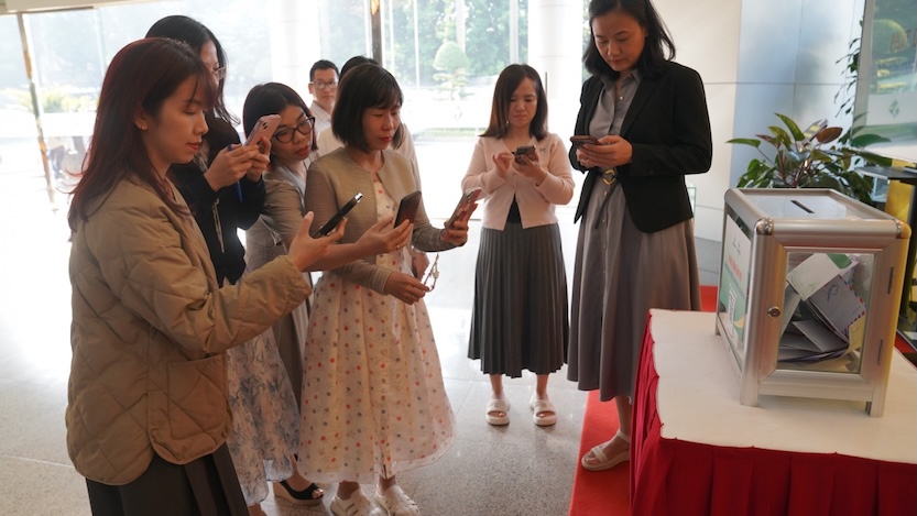 Officers, employees and workers of the Vietnam Oil and Gas Institute scan QR codes to support people in flood-affected areas. Photo: Minh Duc