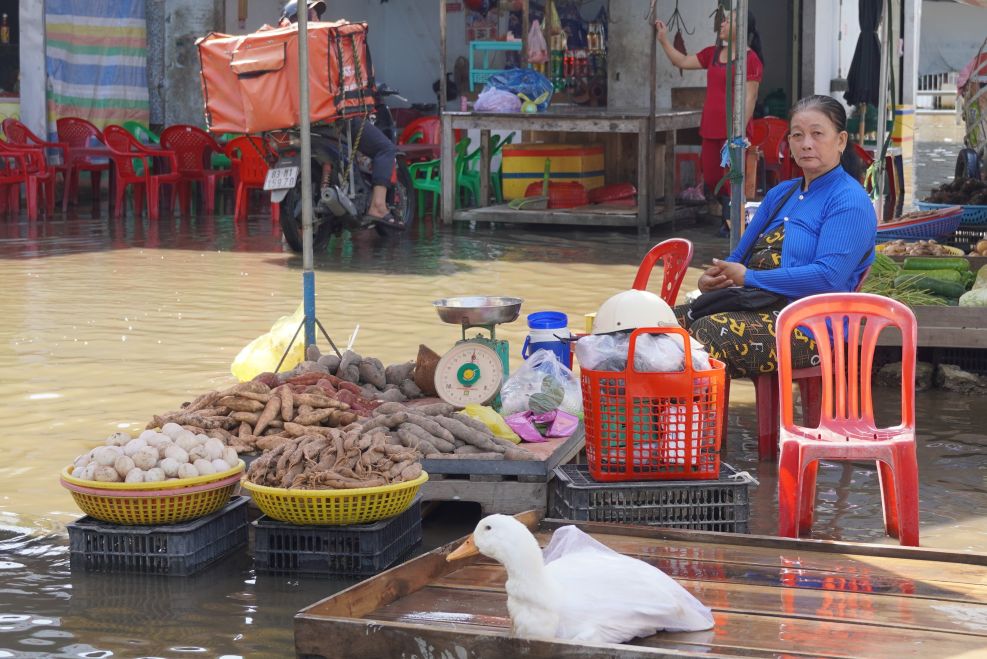 Tiểu thương kê cao hàng hóa để tránh nước ngập tại chợ Huỳnh Hữu Nghĩa. Ảnh: Phương Anh