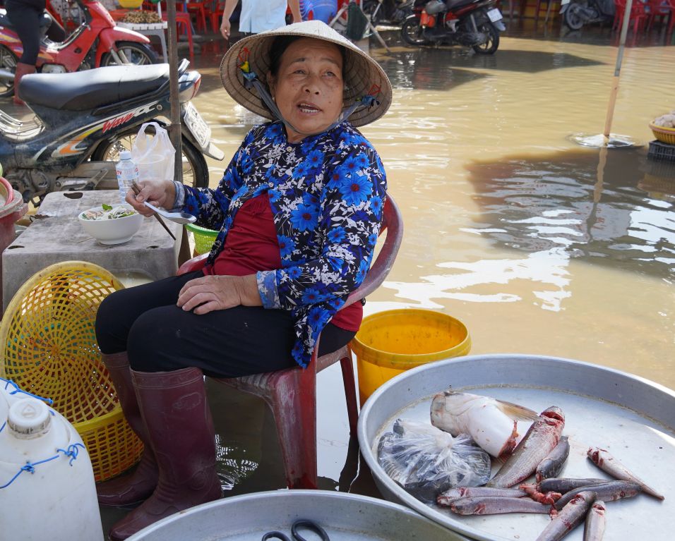Hơn 1 tháng nay bà Nguyễn Thị Tư tiểu thương chợ Huỳnh Hữu Nghĩa (xã Mỹ Tú, TP Cần Thơ) buôn bán trong tình cảnh nước ngập dưới chân. Ảnh: Phương Anh