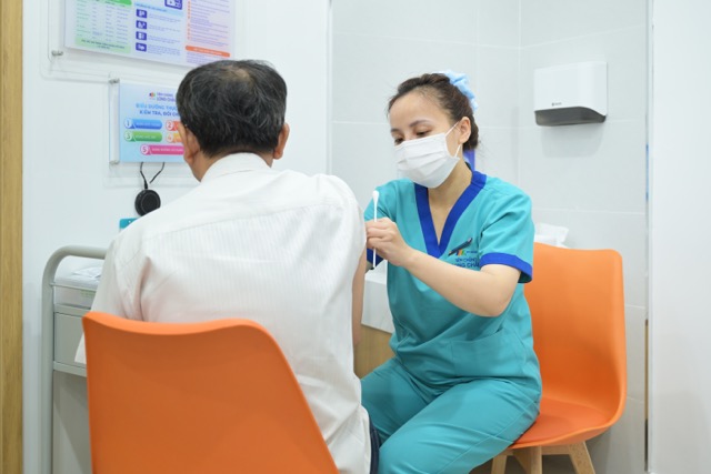 Can bo y te tiem chung vaccine cum cho nguoi dan. Anh: Huong Giang