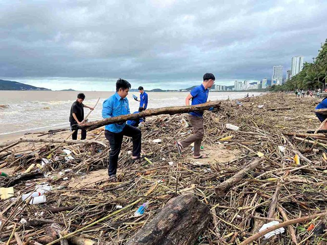 Hang tram sinh vien, doan vien, can bo va cong nhan moi truong tham gia vao viec thu don rac doc bo bien Nha Trang. Anh: Huu Long