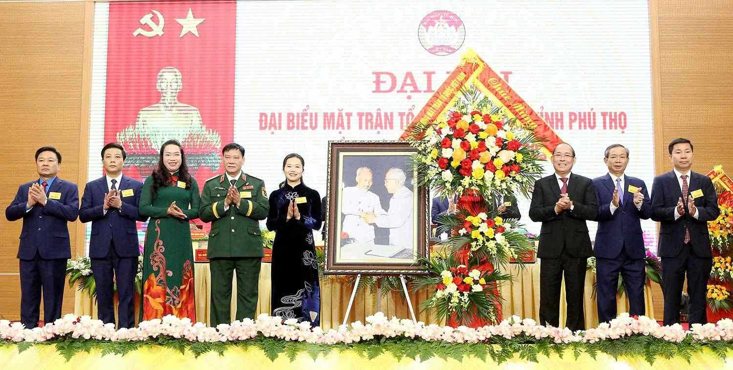 El Vicepresidente del Comite Central del Frente de la Patria de Vietnam Hoang Cong Thuy entrega flores y un cuadro 'Ho Chi Minh y Bac Ton' para felicitar el Congreso. Foto: Thanh Hoa - Ngoc Kien.