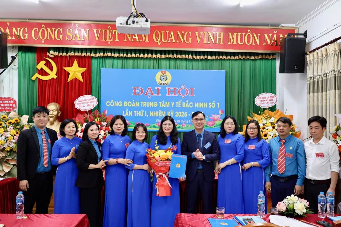 Los lideres entregan flores y entregan la Decision de Reconocimiento del Comite Ejecutivo del Sindicato del Centro Medico Bac Ninh No. 1 por primera vez para el periodo 2025-2030. Foto: Nguyen Huyen