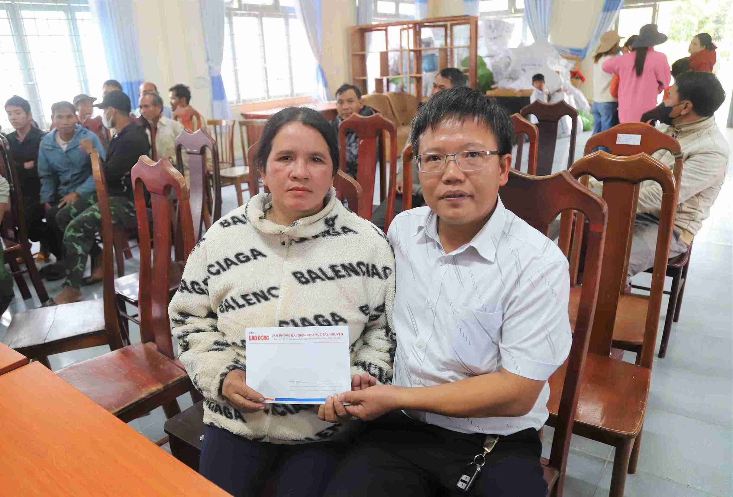Phong vien Bao Lao Dong trao qua tu Quy Tam Long Vang cho ba Lieng Hot K’Thom (thon Da Nhinh 2) co 7 sao ca phe bi lu cuon troi. Anh: Phuc Khanh
