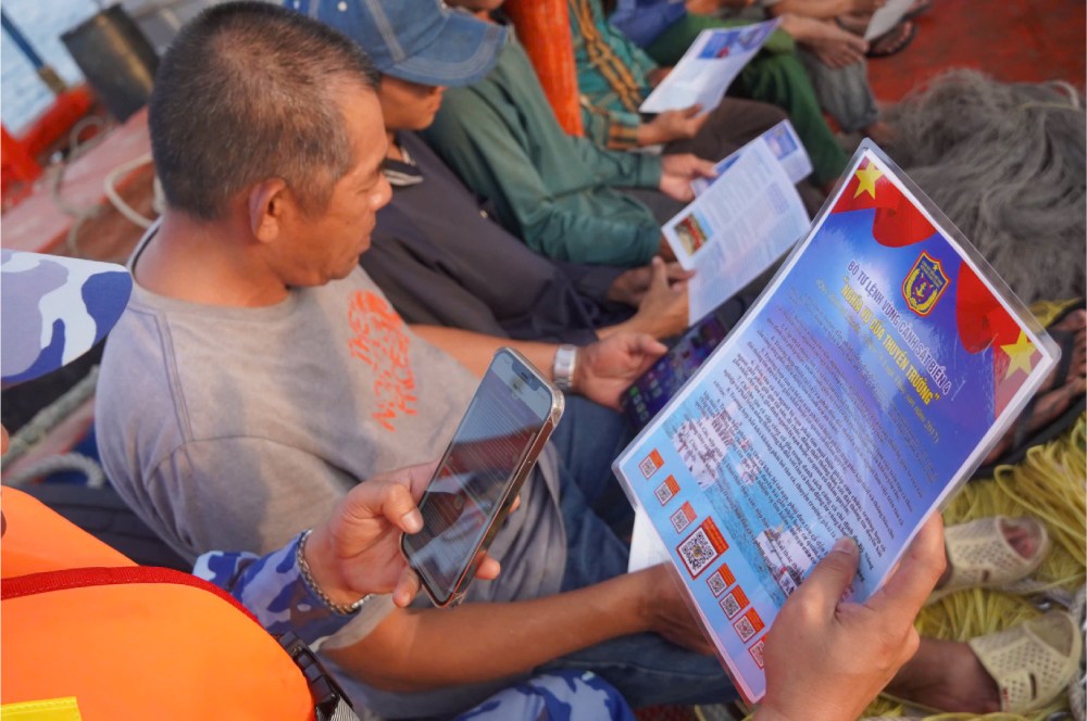 漁船の漁民にQRコードをスキャンして水産法、IUU漁業防止に関する規制に関する情報を確認するよう指導。写真:Nguyen Anh