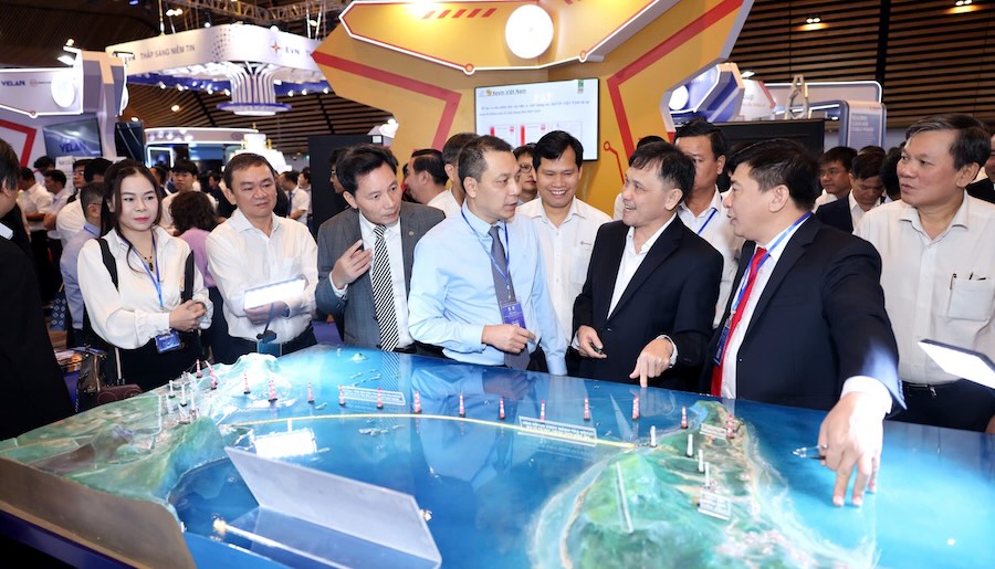 Chairman of EVN Board of Directors Dang Hoang An (blue shirt), Mr. Mai Quoc Hoi - Vice Chairman and General Secretary of Vietnam Electricity Association (gray shirt) and delegates visit EVNSPC booth. Photo: EVNSPC