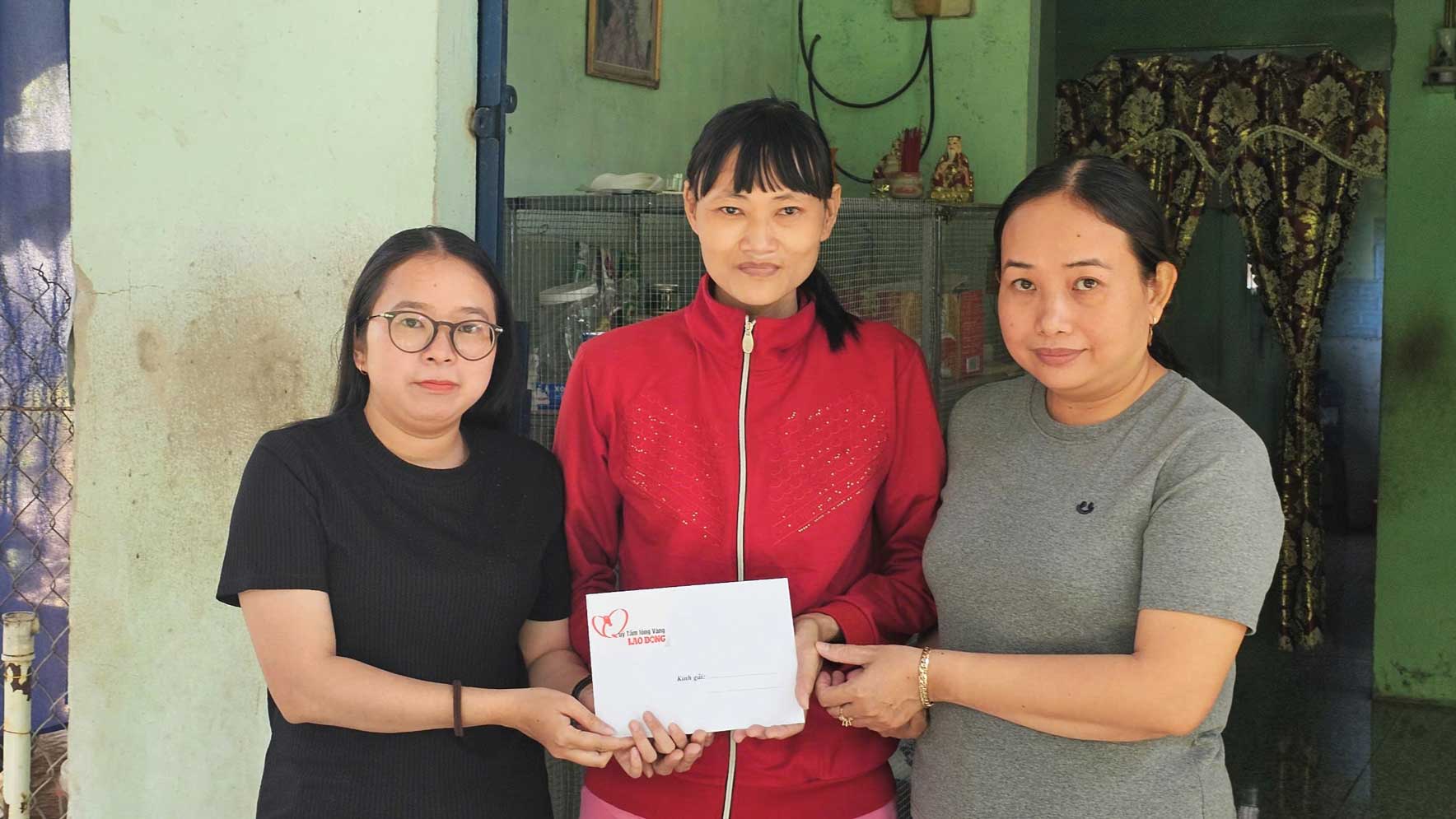 トゥエンさん（中央に立っている）は、ゴールデンハート慈善基金を通じて労働新聞の読者から寄付されたお金を受け取りました。写真: ハン・ギエン
