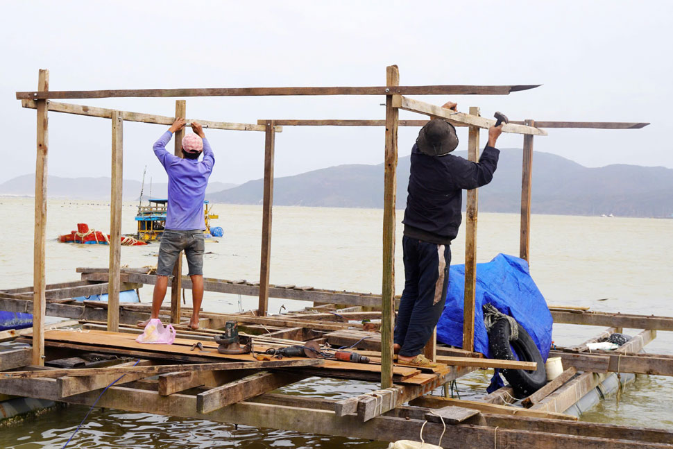 Ngu dan ven bien Quy Nhon dua long be bi hu hong sau bao so 13 vao bo khac phuc. Anh: Hoai Phuong