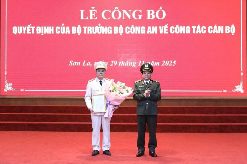 ソンラ省警察署長のDang Trong Cuong少将が決定を授与し、レ・ドゥック・チュン大佐に祝福の花を贈呈。写真:ソンラ省警察.