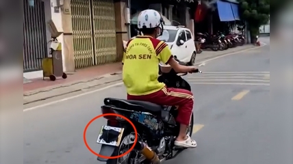 Hinh anh thieu nien chay xe may, dung khau trang che bien so tren duong o TPHCM. Anh: Cat tu clip 