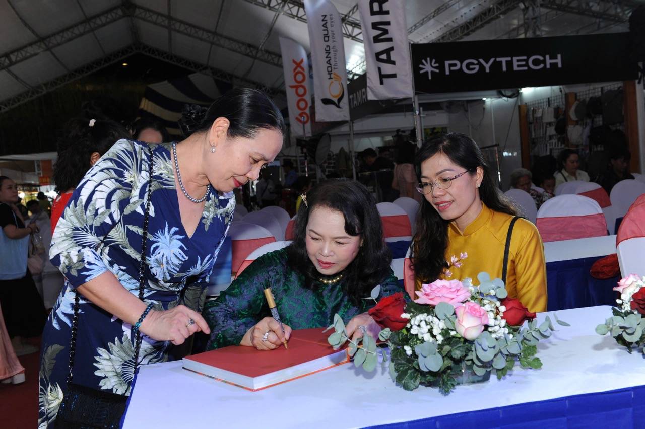 Hoang Thi Bich Thao 작가가 책에 서명합니다. 사진: Minh Anh.