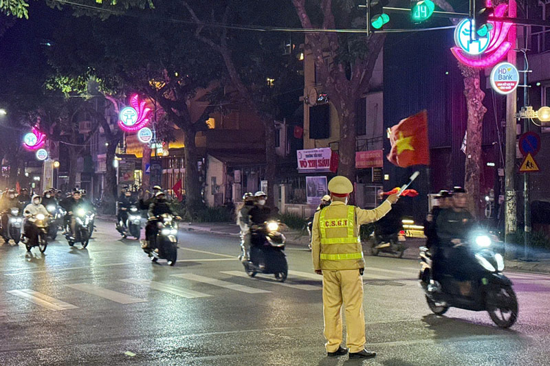 23h tren pho Tran Hung Dao, luc luong CSGT tuc truc dieu tiet giao thong. Du bao trong dem nay khu vuc nay se co luu luong phuong tien di qua rat lon. Luc luong chuc nang khuyen cao nguoi dan can chap hanh tot cac quy dinh cua phap luat ve an toan giao thong. 