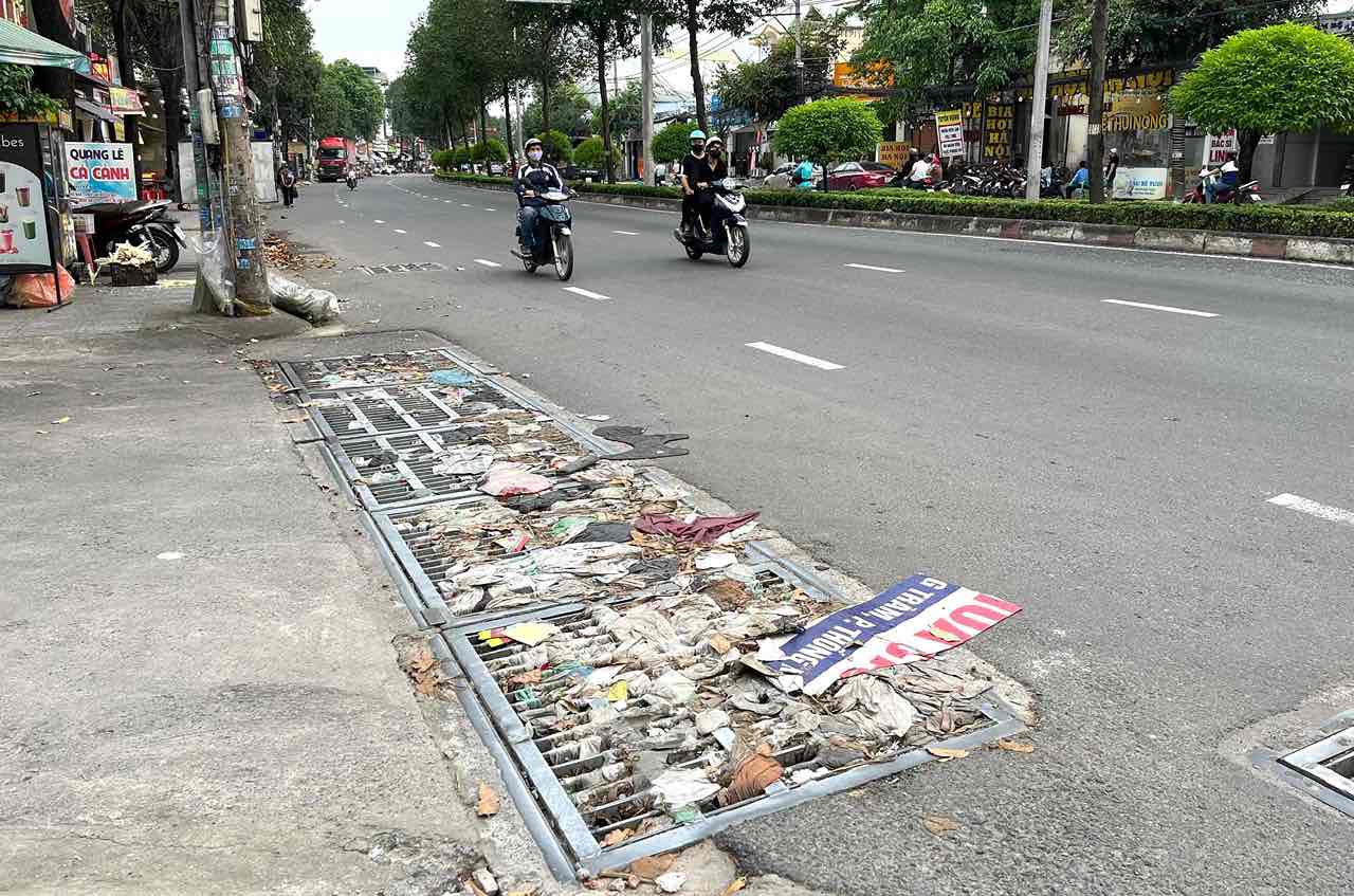 Rác bít kín các miệng cống thoát nước trên đường Đồng Khởi. Ảnh: HAC