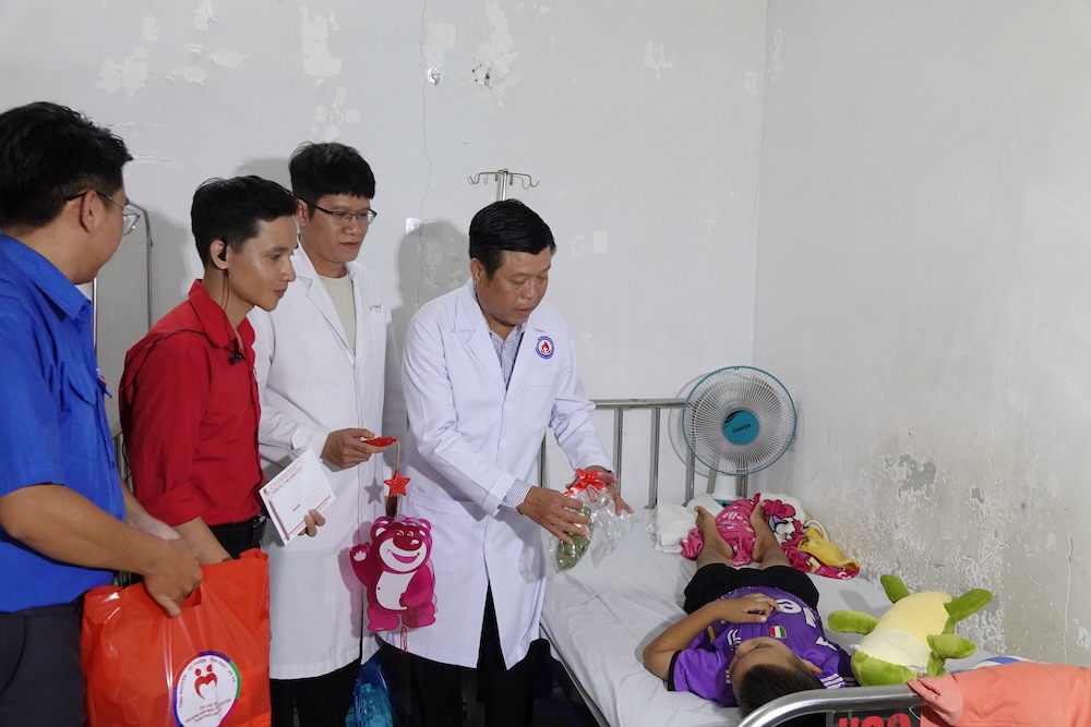 Bac si Le (thu hai tu phai sang) va BS.CK2 Huynh Minh Phu, Giam doc Benh vien Huyet hoc Truyen mau TP Can Tho tham hoi, dong vien benh nhi. Anh: Han Lam.