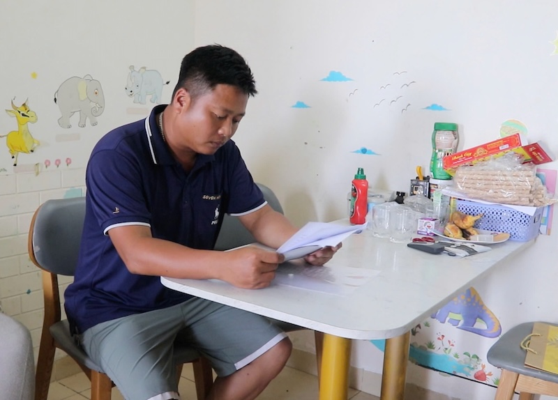 Anh Tran Gia Tan xem lai giay to de lam ho so mua nha o xa hoi. Anh: My Linh