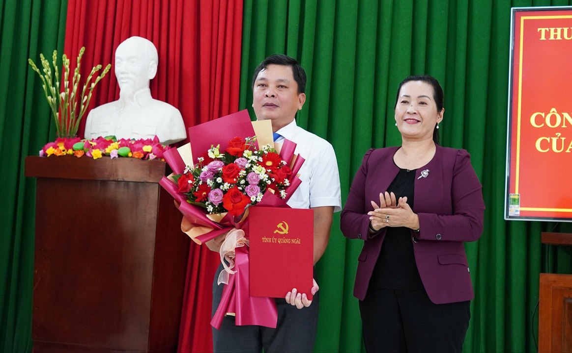 Ms. Dinh Thi Hong Minh - Deputy Secretary of the Quang Ngai Provincial Party Committee presented the decision of the Provincial Party Committee Standing Committee and presented flowers to congratulate the new Secretary of the Ba Gia Commune Party Committee, Vo Xuan Hoa. Photo: Bao Hoa