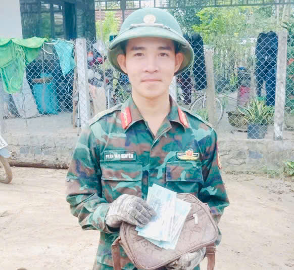 Al recoger dinero mientras limpiaba las inundaciones en Dak Lak el sargento Tran Van Nguyen lo devolvio a la persona que lo habia perdido. Foto: Pham Tung
