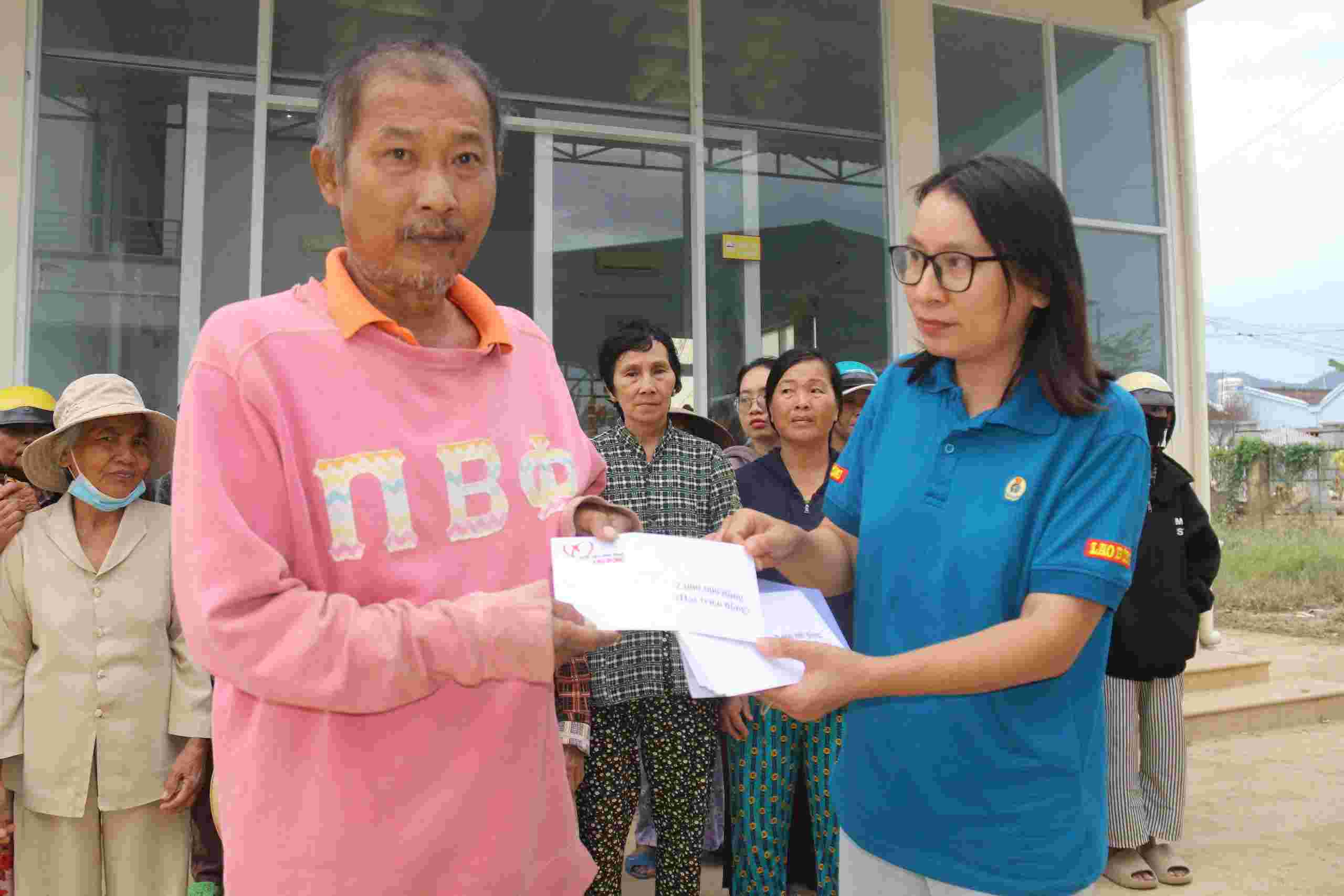 황금 마음 자선 기금 대표가 홍수 피해를 입은 칸호아 주민들에게 지원금을 전달하고 있습니다. 사진: 흐우롱