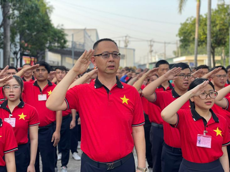 Mr. Hsieh Mao Shan - Chairman of the Board of Directors of Asia Italian option Technology Co., Ltd. and workers held a flag-raising ceremony to celebrate the major national holiday of the Vietnamese people. Photo: Dinh Trong