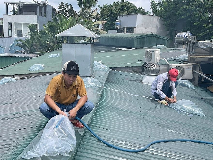 Staff of sake Beer restaurant, located on Phan Boi Chau street, Nghia Lo ward, Quang Ngai province - pumped water into a plastic bag stacked on the roof of the restaurant before storm No. 13 made landfall. Photo: Hoai Thuan