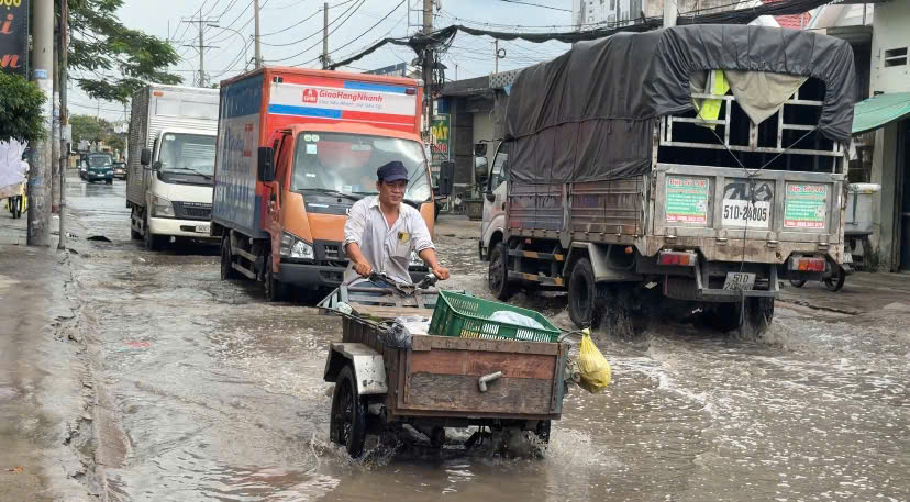 The road to the West of Ho Chi Minh City has been degraded for many months, with flooding causing people to suffer. Photo: Thai Bao.