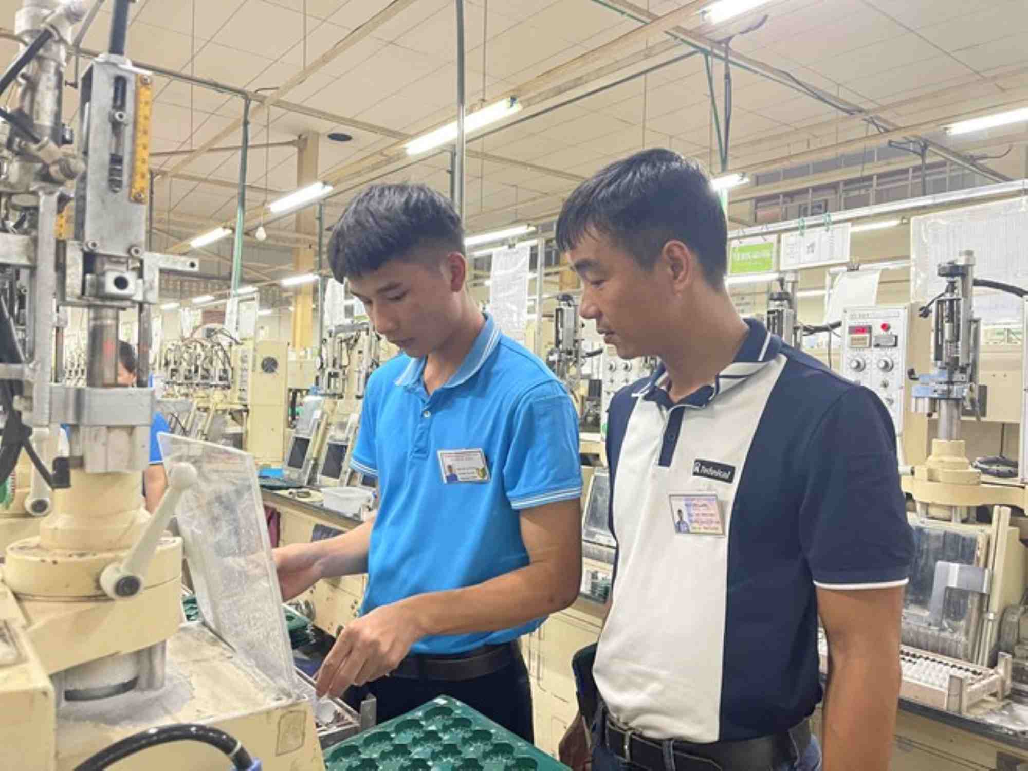 Mr. Nguyen Long (right) enthusiastically teaches workers to do their job. Photo: Character provided
