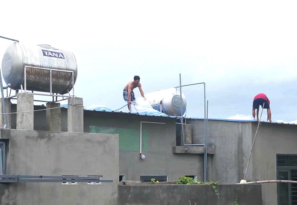 Nguoi dan su dung cac tui nuoc de chan mai nha. Anh: Thanh Quynh