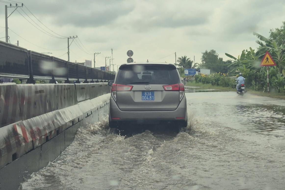 Trieu cuong va mua dan den Quoc lo 1A bi ngap. Anh: Ta Quang