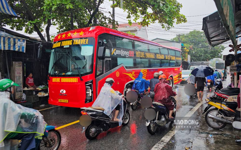 Giao thông vốn rối loạn do mưa lũ, đường An Cựu trở nên ngột ngại, tắc nghẽn khi chiếc xe khổng lồ đi qua. Ảnh: PV