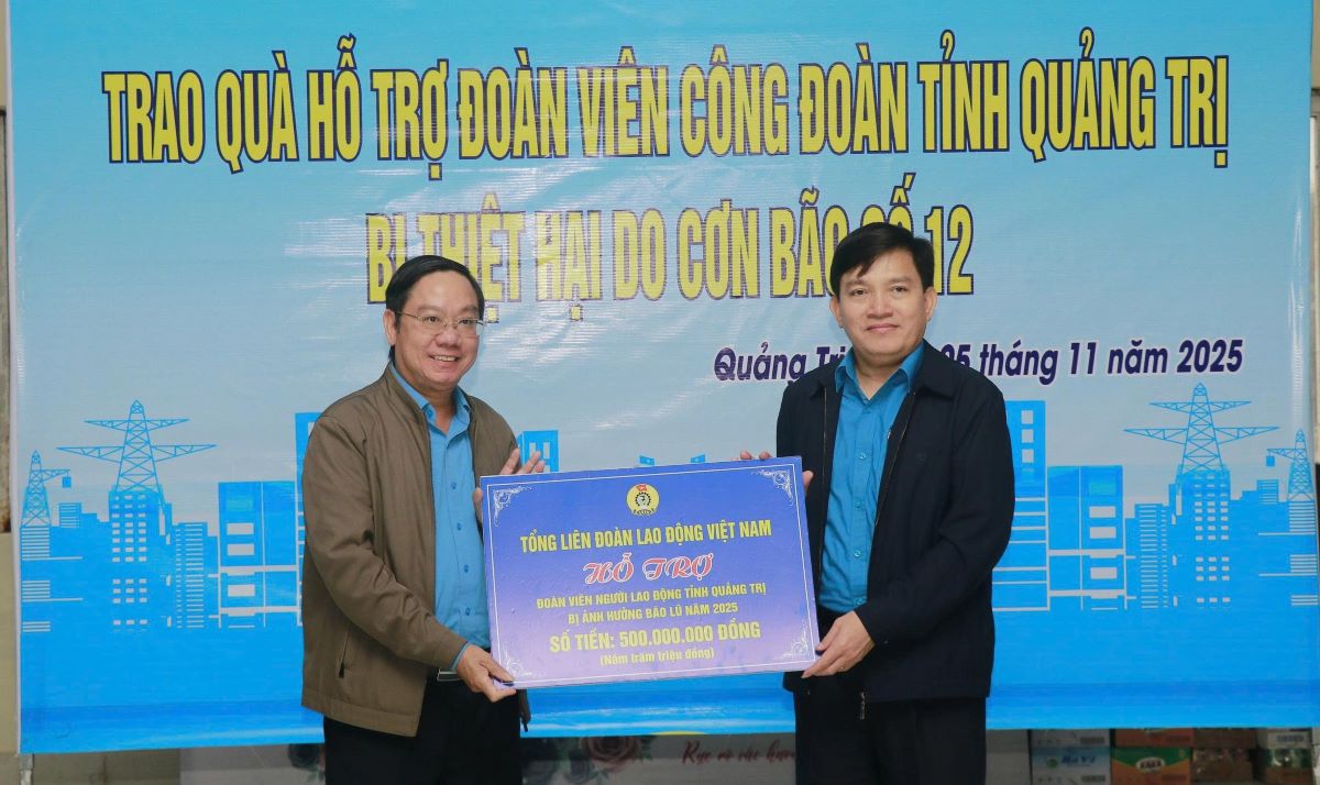 Ong Nguyen Xuan Hung (bia phai anh) – Pho Chu tich Tong LDLD Viet Nam trao bien tuong trung 500 trieu dong cho LDLD tinh Quang Tri. So tien nay se duoc chuyen ve co so, ho tro cho doan vien, cong doan bi anh huong boi mua lu. Anh: Hung Tho