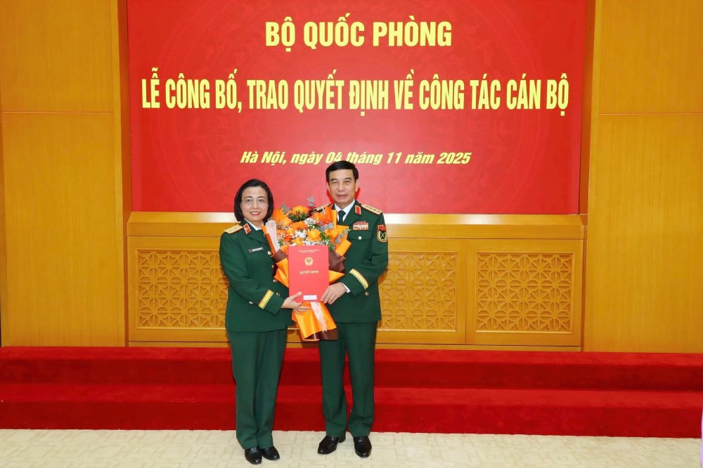 Bo truong Bo Quoc phong Phan Van Giang trao quyet dinh thang quan ham Trung tuong voi ba Nguyen Hoang Ngoc. Anh: Bo Quoc phong