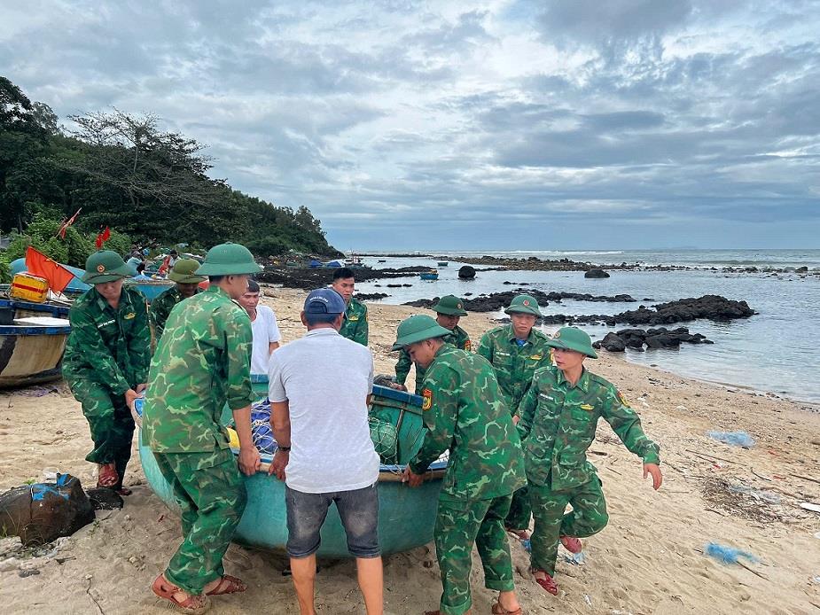 Quang Ngai Provincial Border Guard officers and soldiers help fishermen move their basket boats into the anchorage area safely. Photo: Trong Quoc