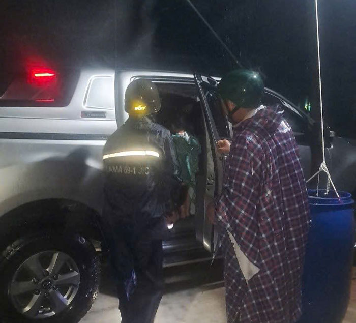 Cong an xa dua hai me con di tranh tru noi an toan. Anh: Cong an