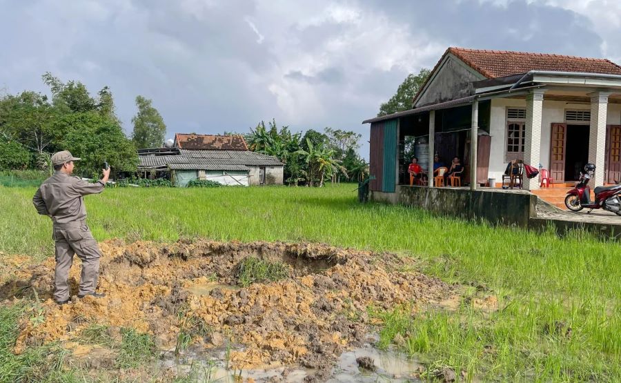 QTMAC staff took the coordinates of the site of the explosion, creating a huge bomb hole near Mr. Tac's house. Photo: Xuan Hien
