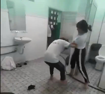 Female students fight in the restroom at Phu An Secondary School. Photo cut from a clip provided by a reader