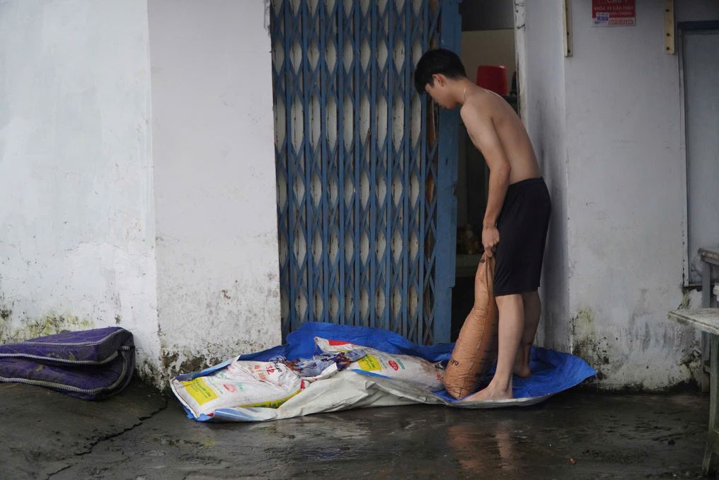 Nguoi dan dung bao cat chan truoc cua nha de ngan nuoc tran vao. Anh: Nguyen Chan