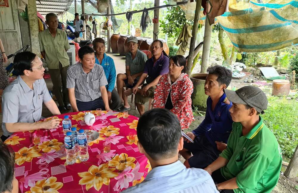 Chu tich UBND tinh (bia trai) tham hoi va dong vien nguoi dan vuot qua kho khan, tiep tuc vuon len on dinh san xuat. Anh: Cong thong tin dien tu Dong Thap. 