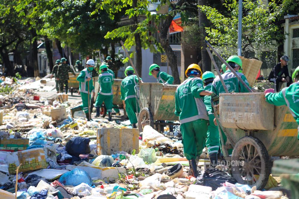 Cac luc luong da khan truong ra quan don dep. Di dau la hang chuc can bo, chien si quan doi cung luc luong cong nhan Cong ty Co phan Moi truong va Do thi Hue.