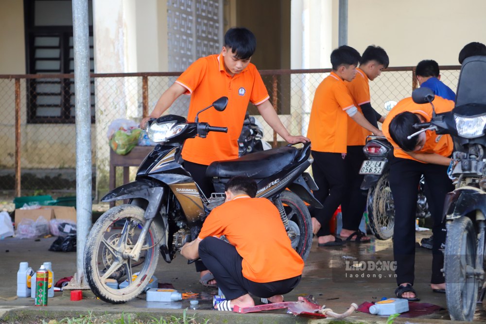 Les etudiants competents du toit de l'ecole du syndicat repasent gratuitement les vehicules pour les habitants des zones inondees de Hue. Photo : Nguyen Luan