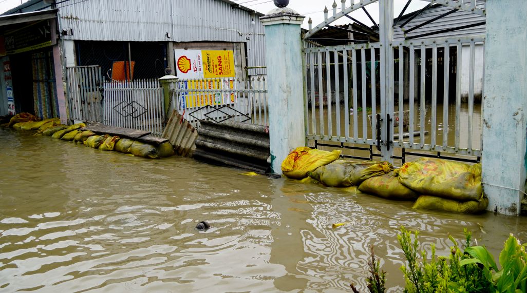 Nguoi dang gia co tam de chong nuoc tran vao nha. Anh: Phuong Anh