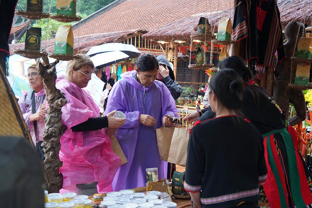 Los turistas occidentales usan lluvia para explorar productos artesanales tradicionales y productos OCOP en Van Mieu - Quoc Tu Giam en el marco del Festival Thang Long - Ha Noi 2025. Pronostico del tiempo de Hanoi con lluvia y humedad hasta el final del fin de semana. Foto: Hue Nghiem