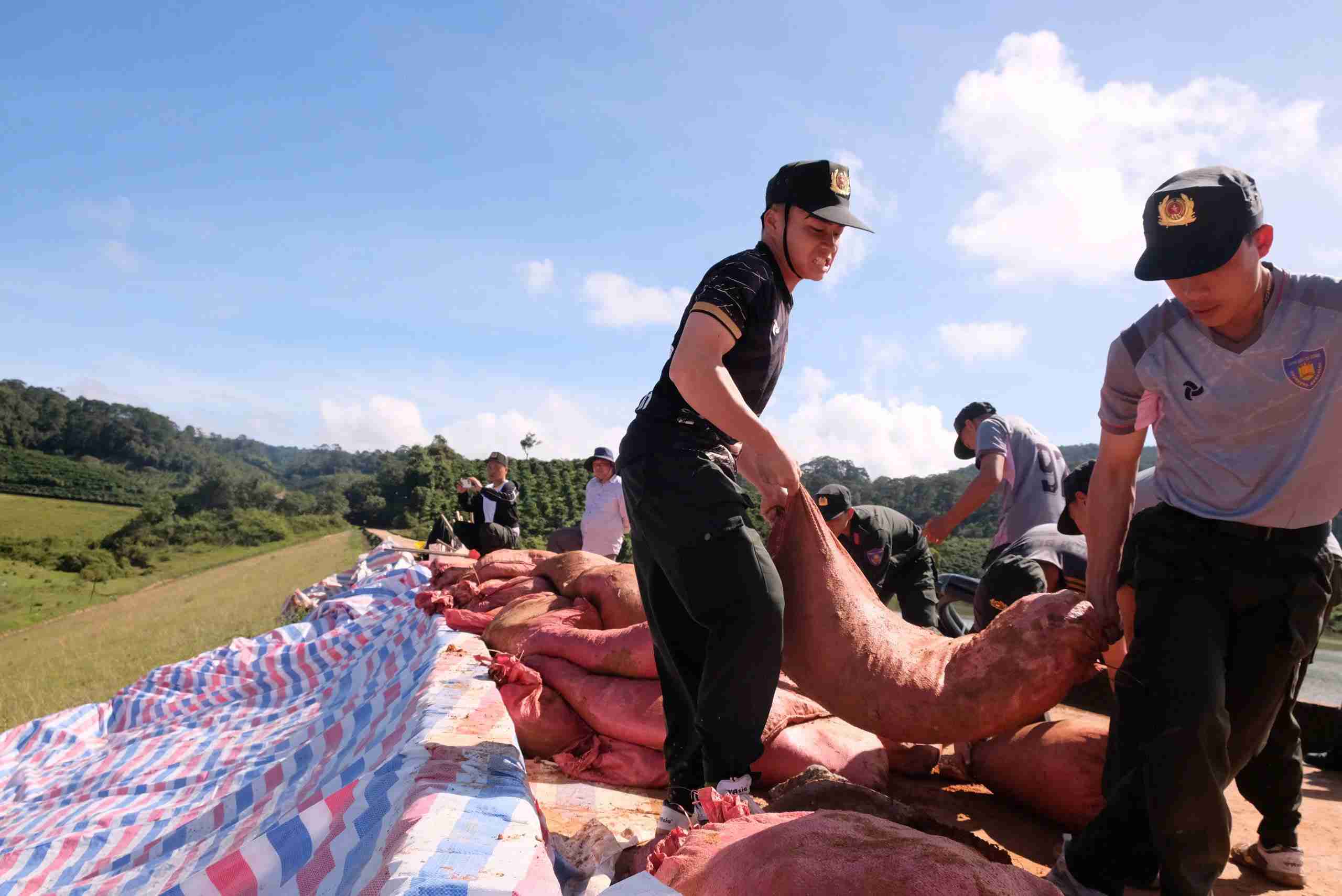 Can bo, chien si Canh sat Co dong Cong an tinh Lam Dong no luc van chuyen dat, da gia co than dap giua trua nang khien mo hoi uot dam. Anh: Phuc Khanh