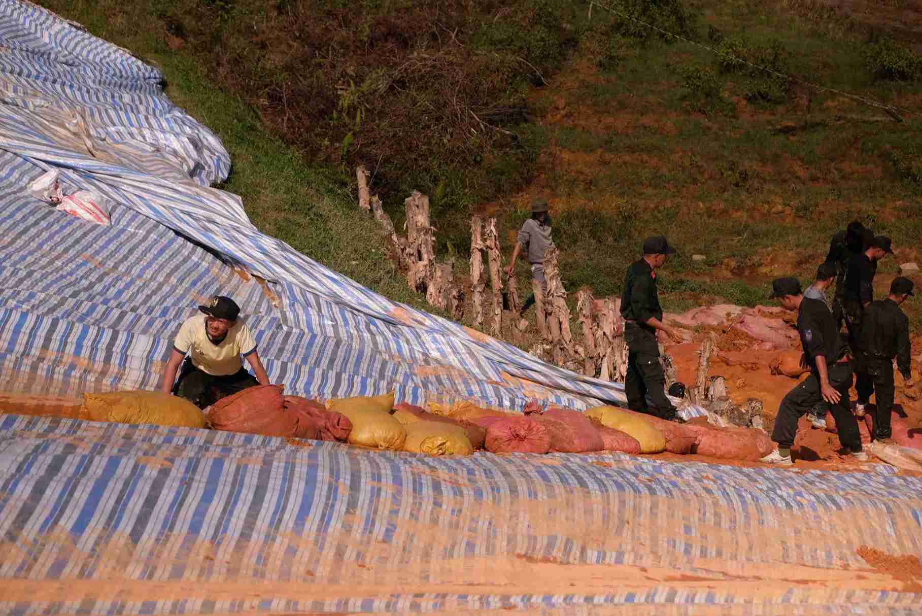 Nhung bao tai dat lien tuc duoc lap vao vi tri xung yeu tren than dap ho thuy loi Cay An sau khi duoc phu bat. Anh: Phuc Khanh