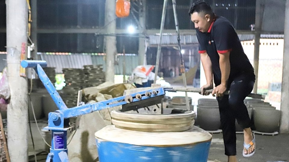 Cong nhan thao tac tren thiet bi moi trong xuong gom. Anh: Hoang Loc